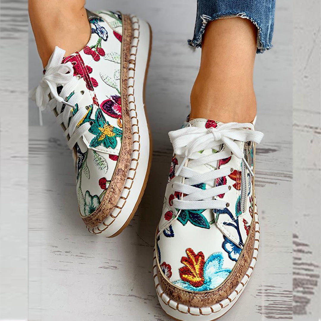 Witte sneakers met kleurrijke bloemenprint, veters en gevlochten zool. Modieuze damesschoenen, casual stijl, perfect voor lente en zomer.