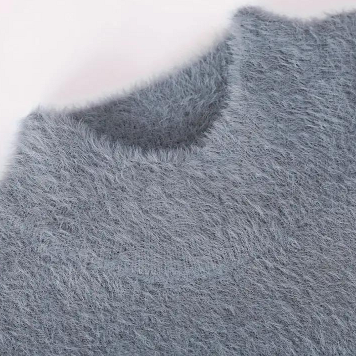 Grijze pluizige trui met ronde hals, zachte textuur, close-up. Perfect voor wintermode, warme kleding, comfortabele stijl.