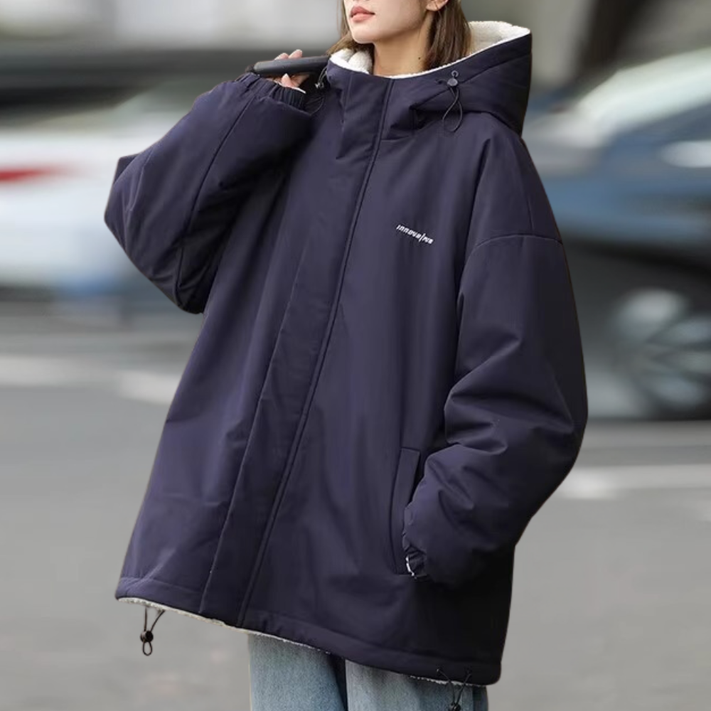 Vrouw in oversized donkerblauwe winterjas met capuchon, casual mode, buitenkleding, trendy streetwear, comfortabele warme jas voor dames.