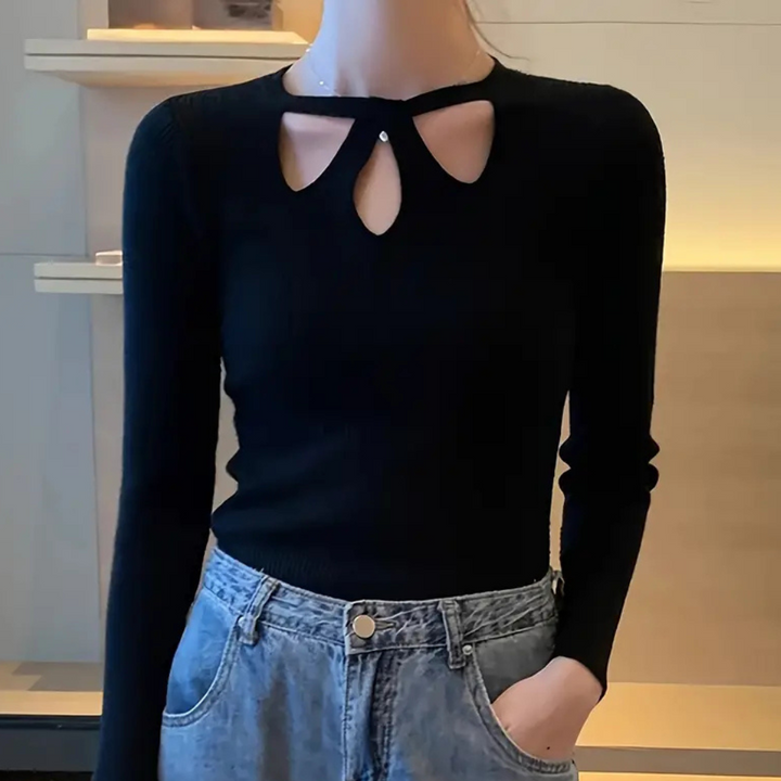 Zwarte trui met lange mouwen en unieke halslijn, gedragen door model. Modieuze dameskleding, perfect voor casual en chique outfits.