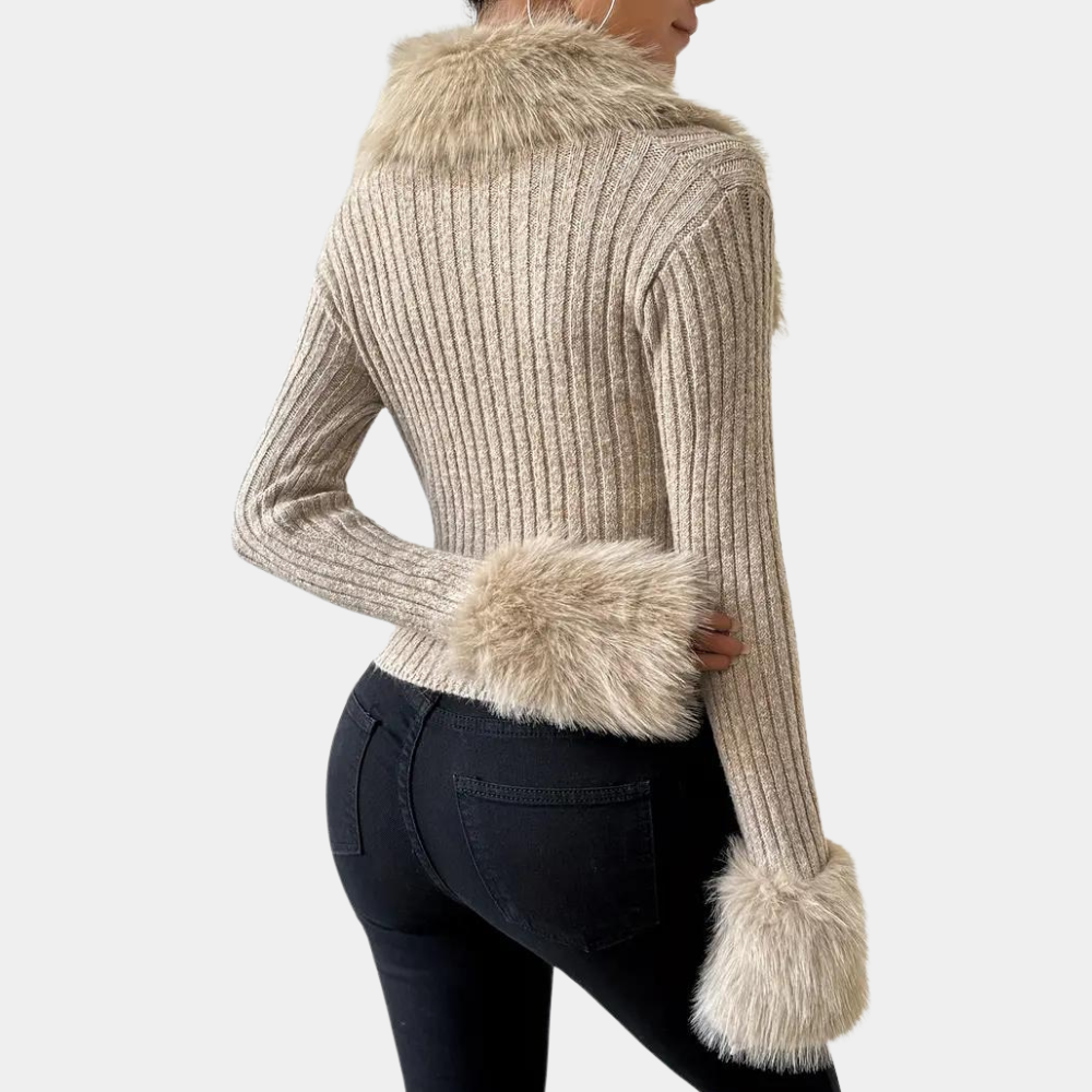 Beige geribbelde trui met nepbont kraag en manchetten, gedragen door model in zwarte jeans. Modieuze dameskleding, herfst-winter stijl.