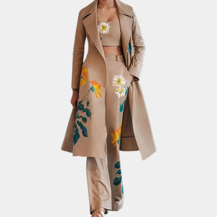 Driedelig damespak met bloemenprint, bestaande uit een lange jas, top en broek. Modieuze beige outfit met kleurrijke bloemenmotieven.
