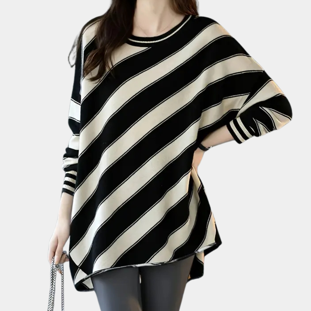 Vrouw draagt oversized zwart-wit gestreepte trui, modieuze casual outfit, comfortabele dameskleding, trendy herfstmode.