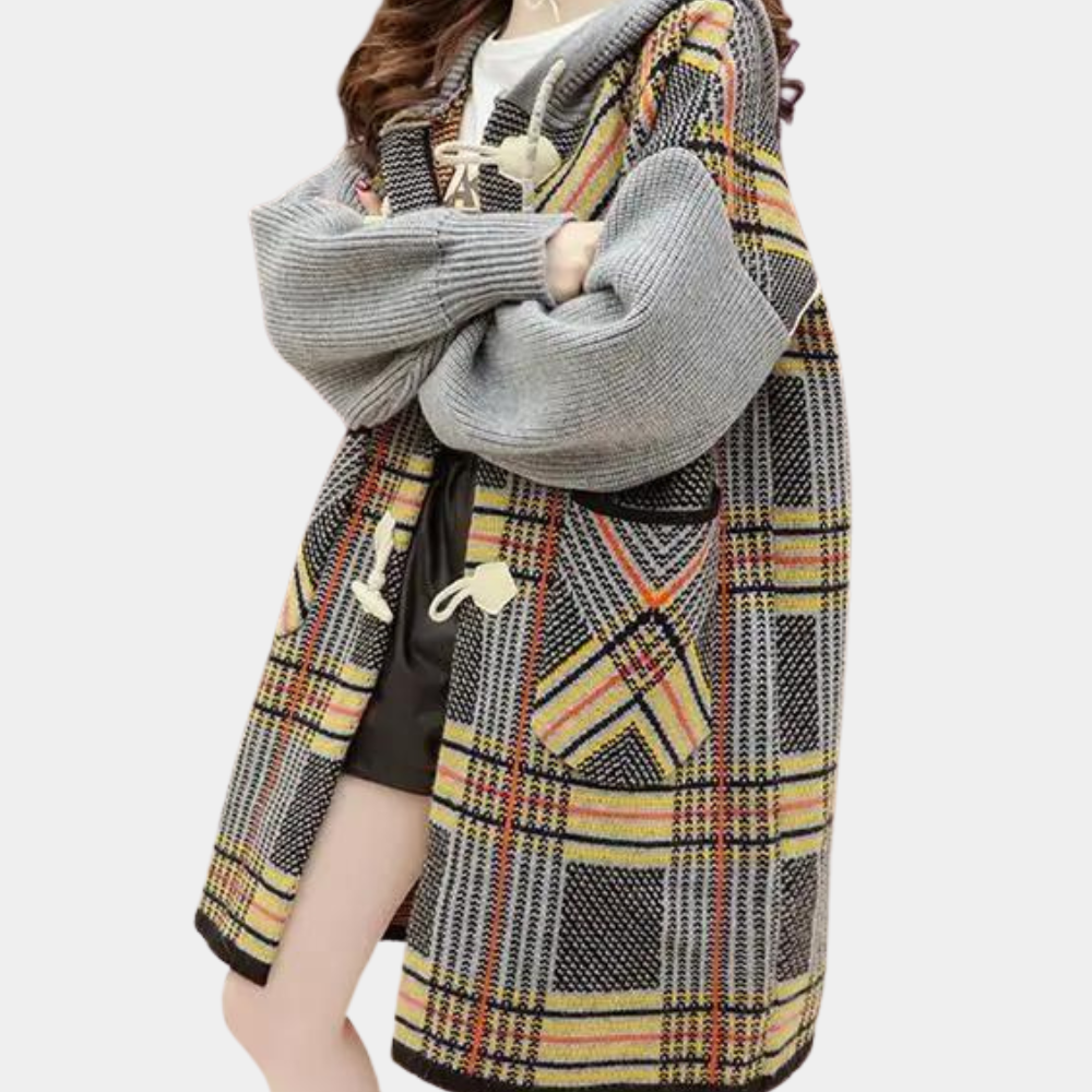 Vrouw draagt oversized geruite jas met grijze mouwen en houtje-touwtje sluiting, modieuze herfstkleding, trendy damesmode, casual stijl.