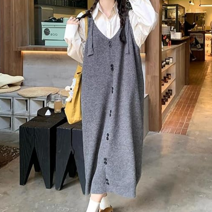 Vrouw in grijze gebreide jurk met knopen, witte blouse, gele tas, casual mode, moderne winkelomgeving, trendy herfstoutfit.