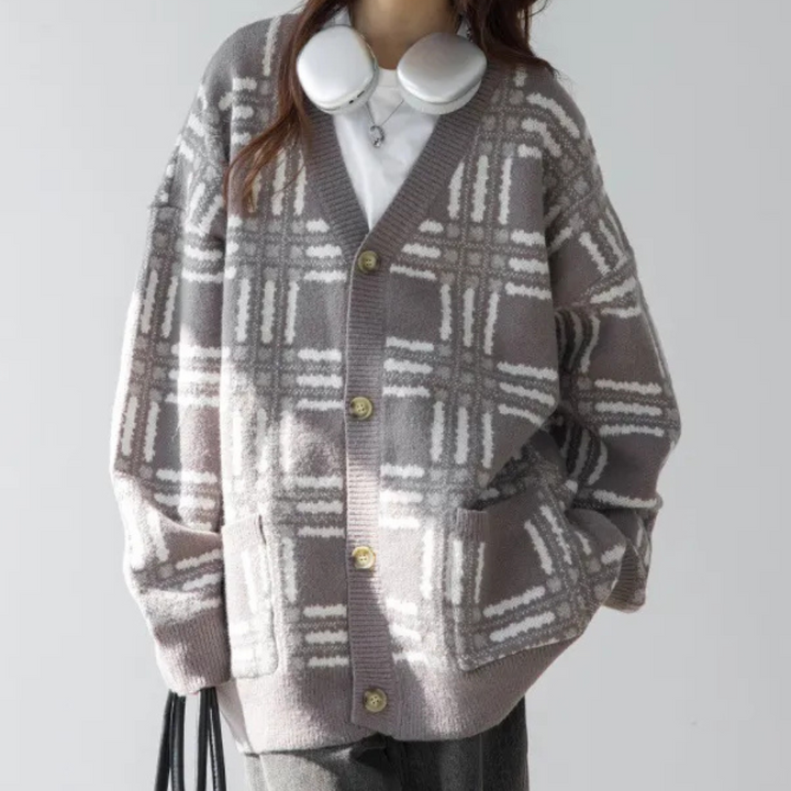 Grijze oversized geruite cardigan met knopen, gedragen door een persoon met koptelefoon. Modieuze dameskleding, herfst- en winterstijl.