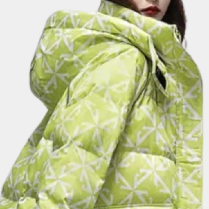 Lichtgroene gewatteerde jas met witte geometrische patronen, capuchon en ritssluiting. Modieuze winterjas voor dames, trendy en warm.