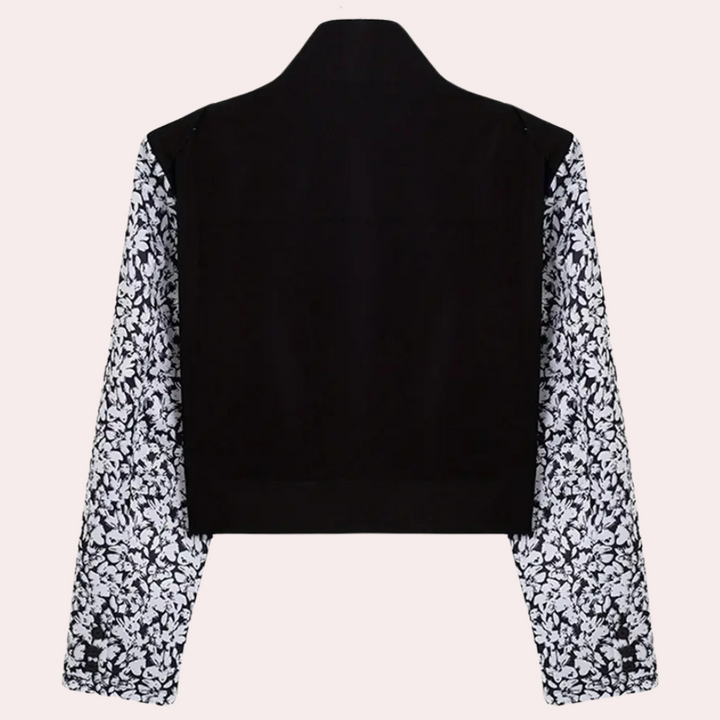 Zwarte blazer met lange mouwen en wit bloemenpatroon, stijlvolle damesmode, elegante kleding, trendy design, geschikt voor formele gelegenheden.