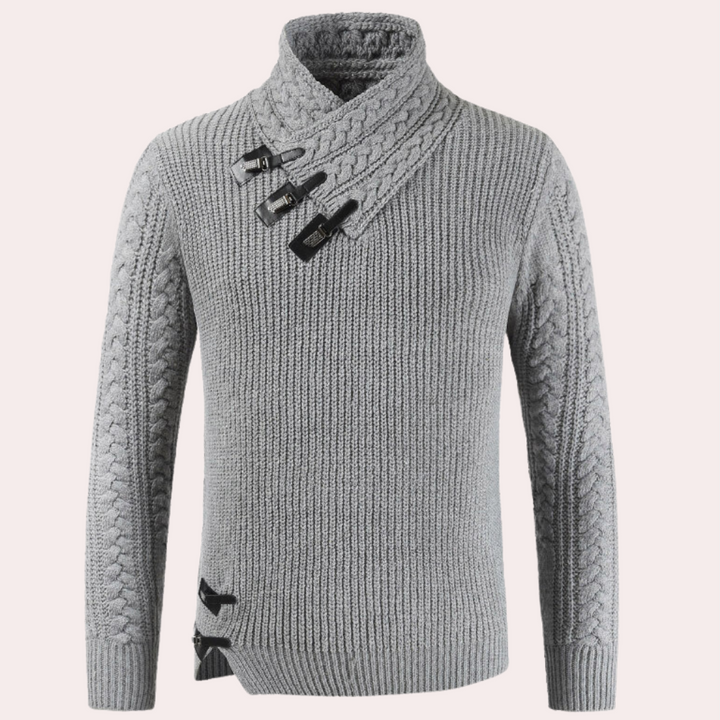 Grijze gebreide trui met asymmetrische kraag en decoratieve gespen, kabelpatroon op mouwen. Stijlvolle herentrui, wintermode, warme kleding.