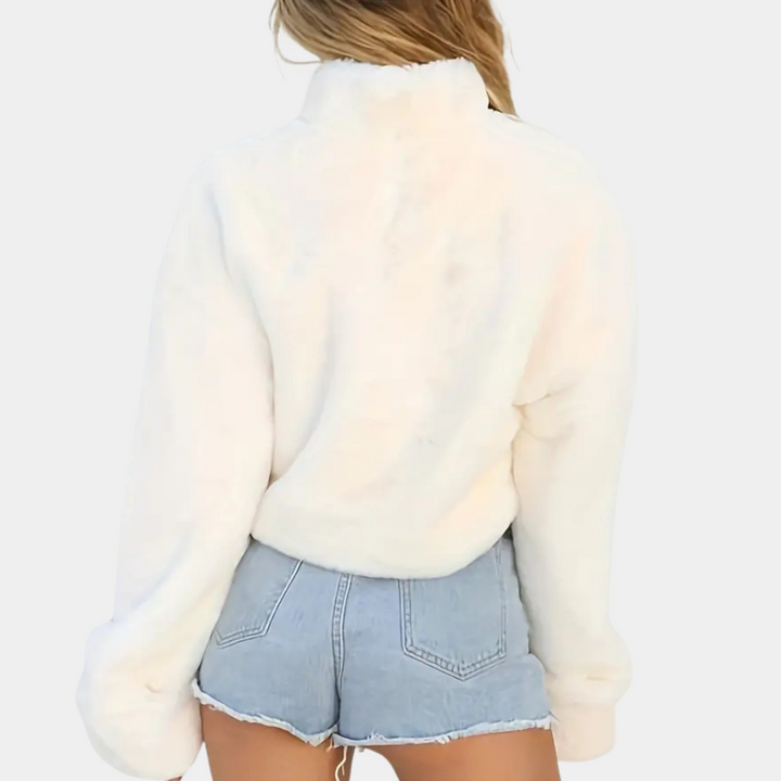 Vrouw in witte fleece trui en blauwe denim shorts, rugaanzicht. Modieuze winterkleding, casual stijl, comfortabele outfit.