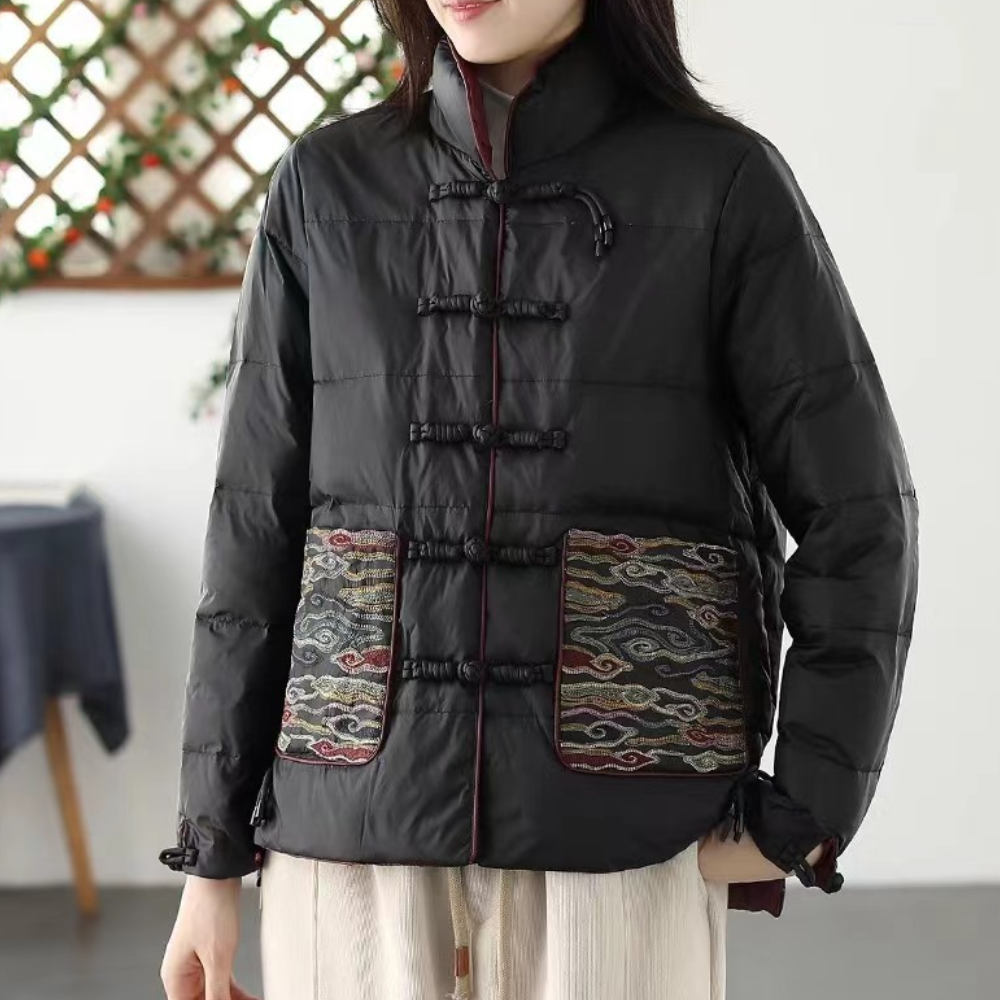 Zwarte gewatteerde jas met traditionele Chinese knopen en kleurrijke geborduurde zakken, ideaal voor wintermode en casual stijl.