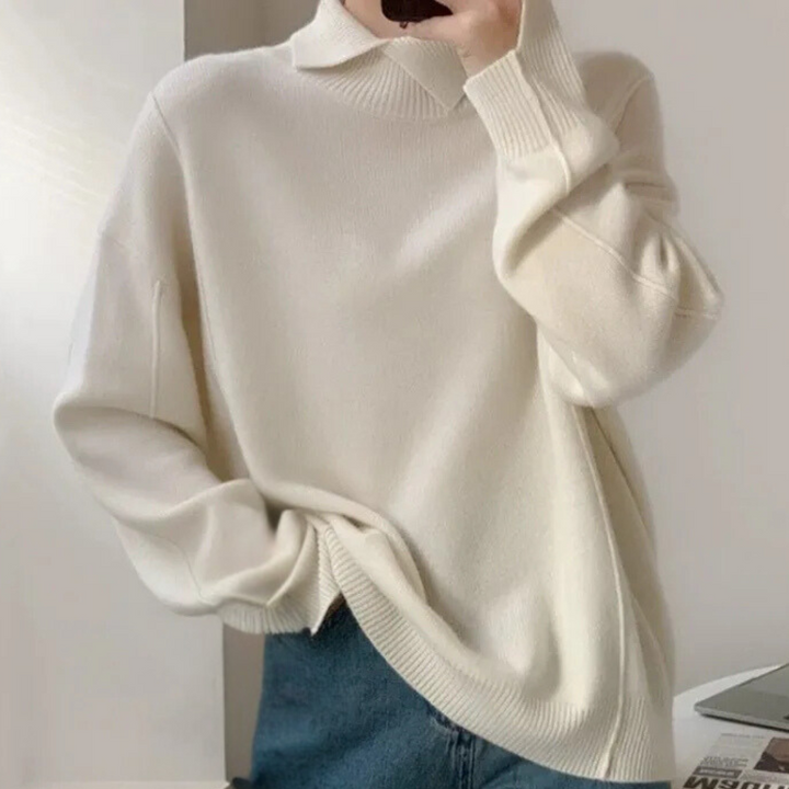 Witte oversized trui, casual stijl, lange mouwen, zachte stof, gedragen door persoon met blauwe jeans. Comfortabele herfst- en wintermode.