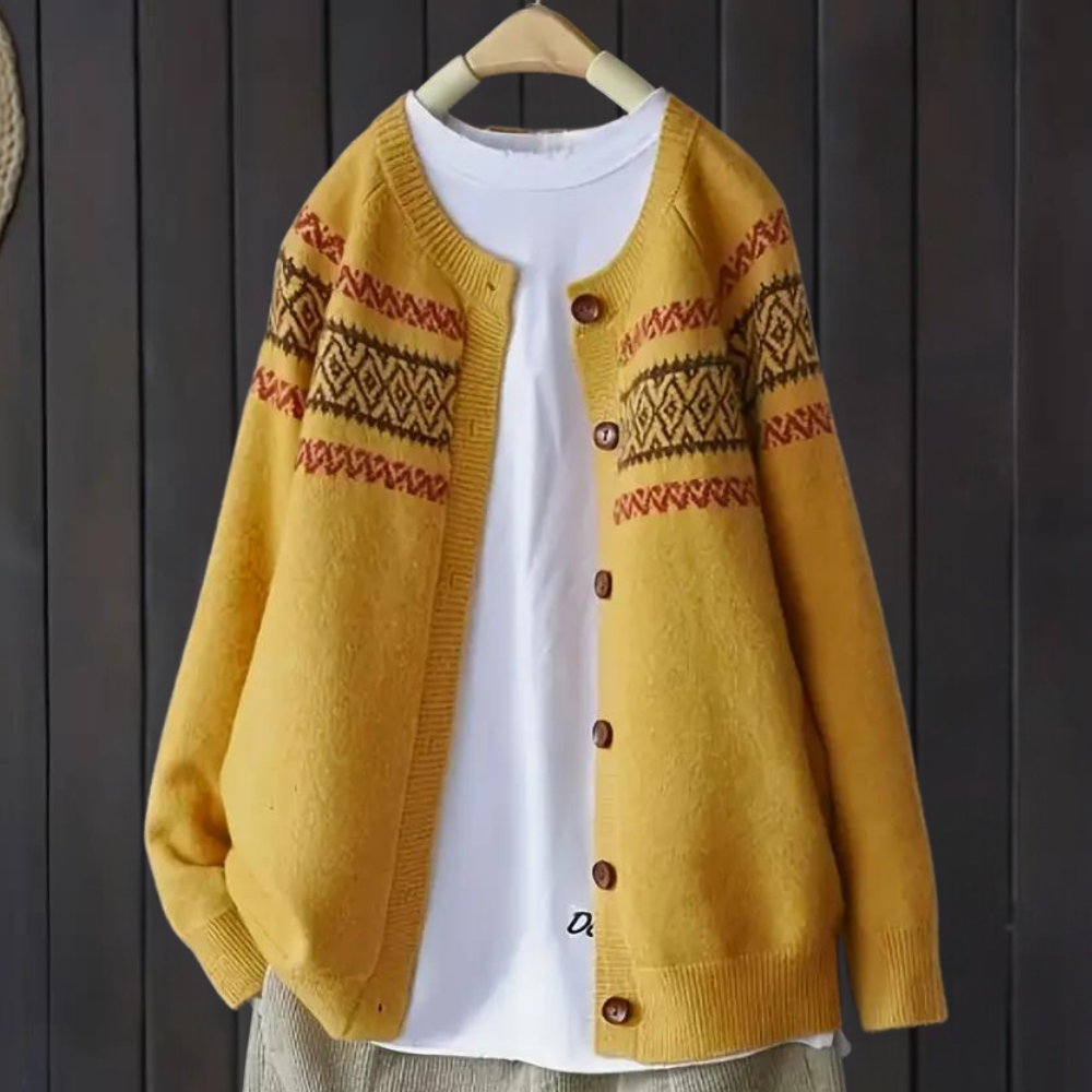 Gele gebreide cardigan met etnisch patroon, houten knopen en witte T-shirt op hanger. Herfstmode, warme dameskleding, casual stijl.