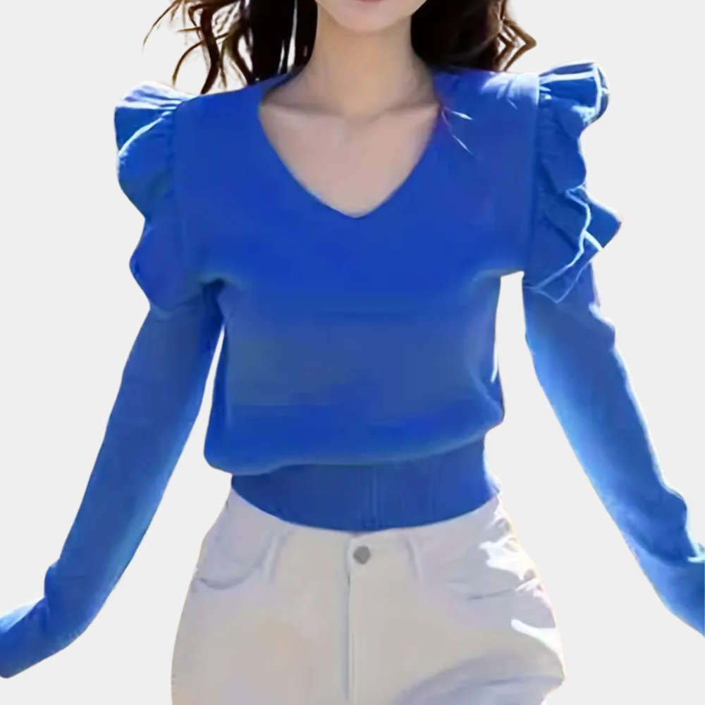 Vrouw in blauwe blouse met ruches en V-hals, gecombineerd met witte broek. Modieuze dameskleding, trendy outfit, casual stijl.