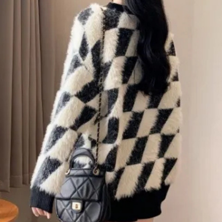 Vrouw in zwart-witte geruite trui met harig patroon, draagt een zwarte leren handtas. Stijlvolle wintermode, trendy dameskleding.