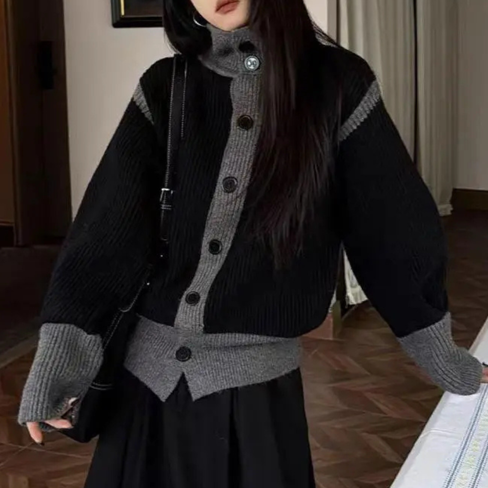 Vrouw in stijlvolle zwart-grijze gebreide trui met knopen, modieuze winterkleding, trendy damesmode, comfortabele en warme outfit.