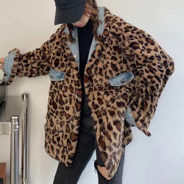 Vrouw in oversized luipaardprint jas met denim details, zwarte pet en gescheurde jeans. Modieuze streetwear outfit, trendy herfstkleding.