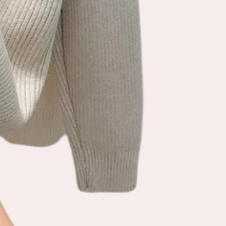 Grijze gebreide trui met lange mouwen, close-up. Zachte stof, casual stijl. Perfect voor herfst- en wintermode. Comfortabele dameskleding.