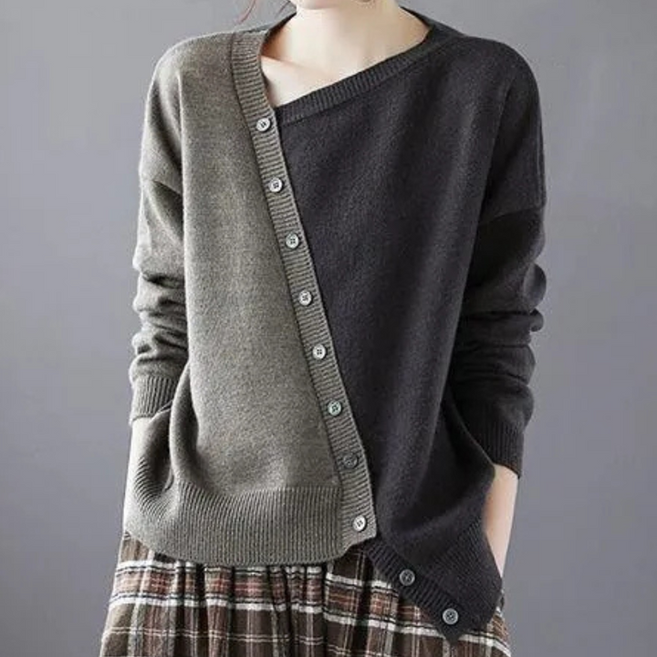 Grijze en olijfgroene asymmetrische damestrui met knopen, gecombineerd met geruite rok. Modieuze herfstkleding, casual stijl.