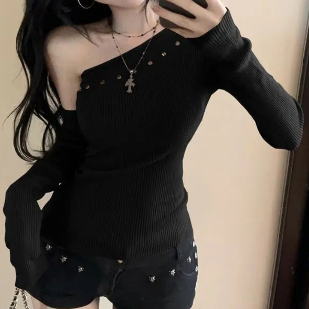Vrouw in zwarte off-shoulder top met lange mouwen en studs, draagt een ketting. Modieuze dameskleding, trendy outfit, casual stijl.