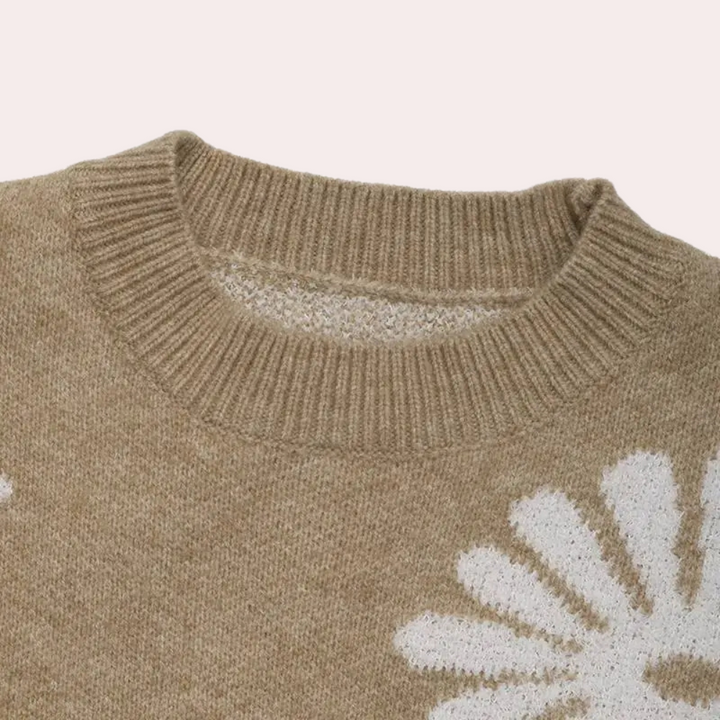 Beige trui met ronde hals en witte bloemmotieven, gebreid van zachte wol. Perfect voor herfstmode en casual outfits. Comfortabel en stijlvol design.