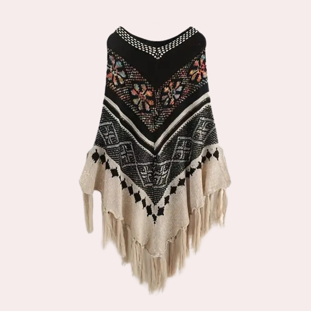 Boho poncho met kleurrijk bloemenpatroon, zwarte en witte geometrische strepen, en franjes. Perfect voor herfstmode en bohemian stijl.