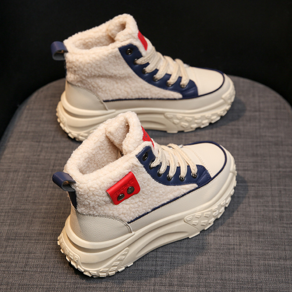 Witte en blauwe winterlaarzen met dikke zool en rode accenten, gemaakt van imitatiebont en leer, perfect voor koude weersomstandigheden.