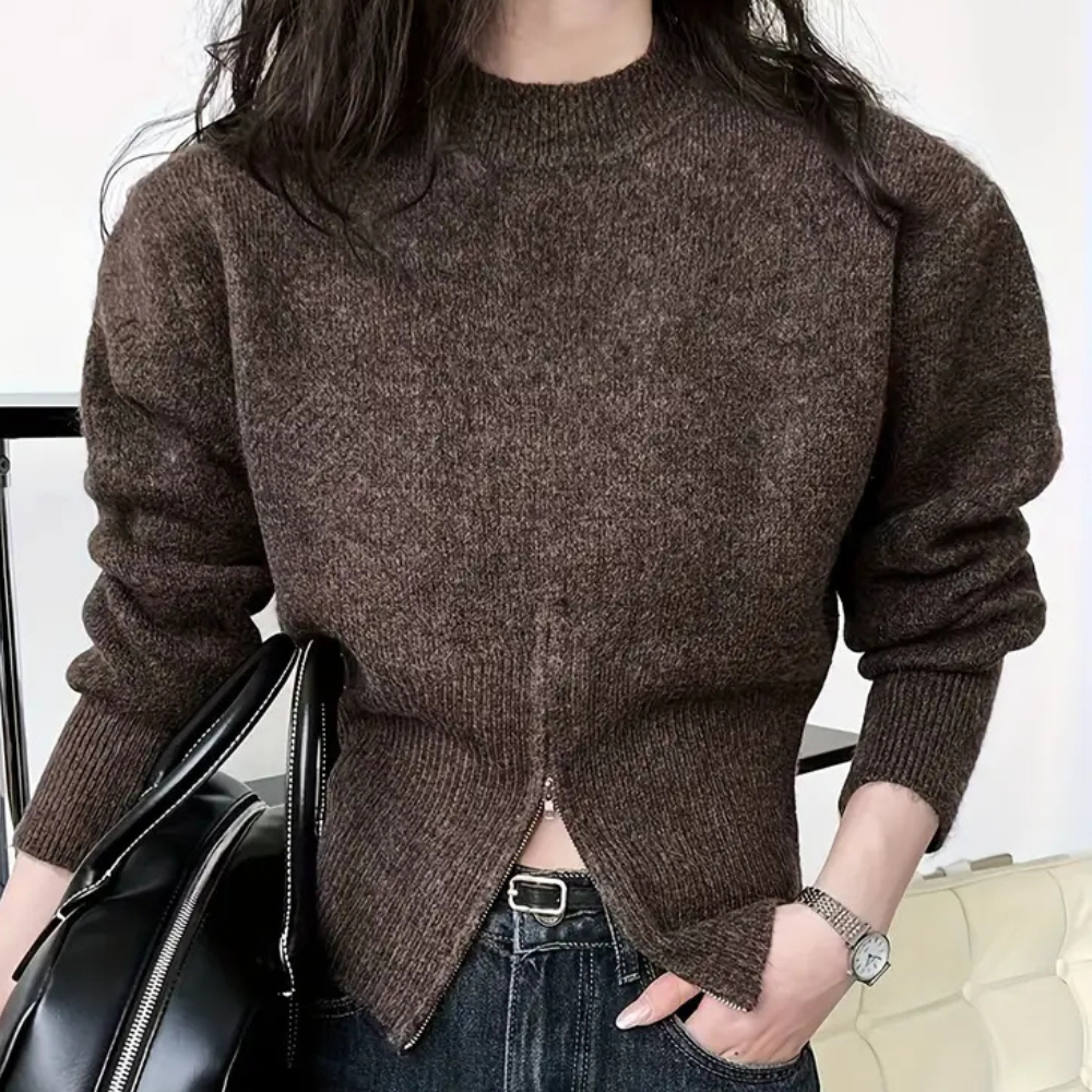 Vrouw in bruine trui met ritssluiting, draagt zwarte leren tas en horloge, casual mode, herfstkleding, trendy damesoutfit, comfortabele stijl.