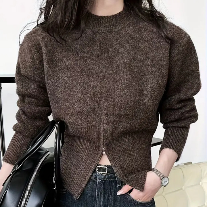 Vrouw in bruine trui met ritssluiting, draagt zwarte leren tas en horloge, casual mode, herfstkleding, trendy damesoutfit, comfortabele stijl.