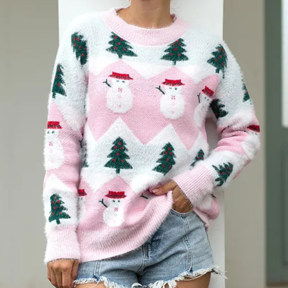 Roze kersttrui met sneeuwpop- en kerstboomprint, gedragen door persoon in spijkershorts. Perfect voor feestdagen, wintermode, casual stijl.
