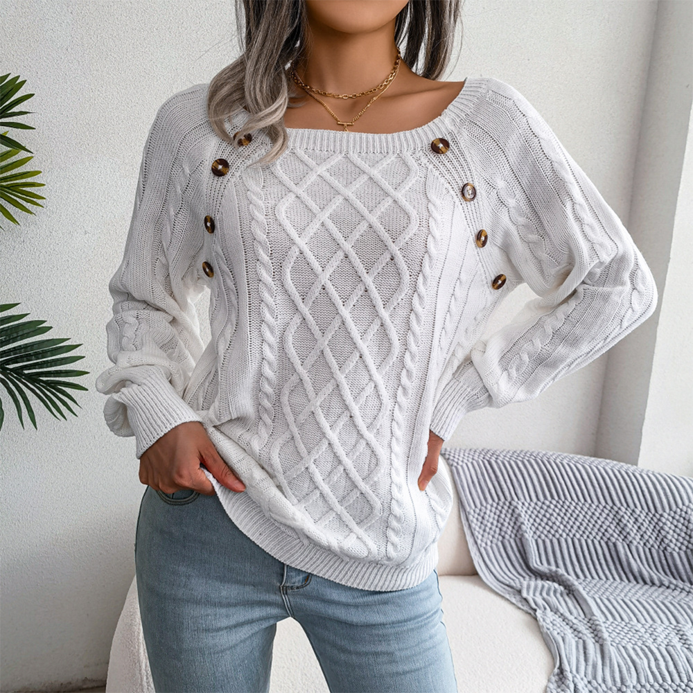 Vrouw draagt witte kabeltrui met knopen, casual stijl, gecombineerd met lichtblauwe jeans. Perfect voor herfstmode en comfortabele outfits.