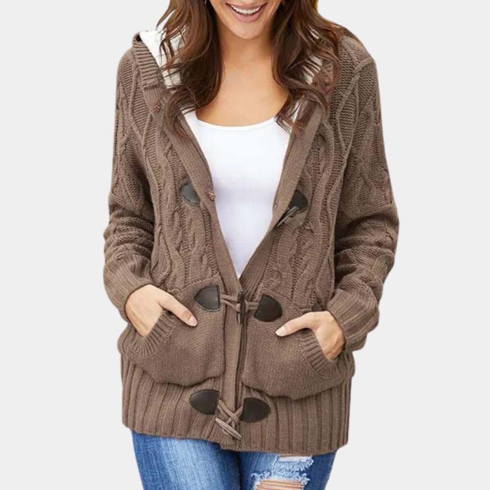 Bruine gebreide damesvest met houtje-touwtje sluiting, witte top en blauwe spijkerbroek. Modieuze herfstkleding, comfortabele casual stijl.
