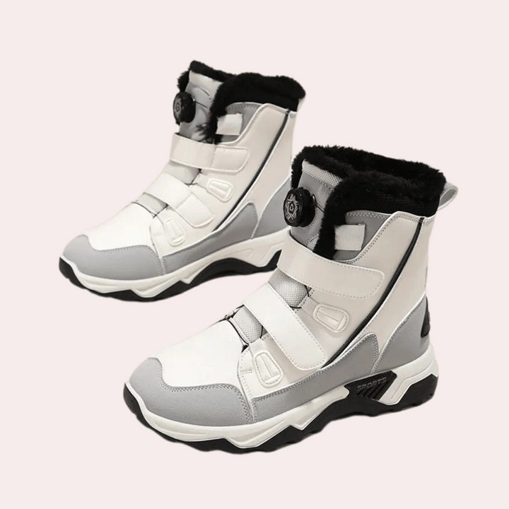 Witte en grijze winterlaarzen met klittenbandsluiting en zwarte voering, ideaal voor koude weersomstandigheden. Comfortabele en stijlvolle dameslaarzen.