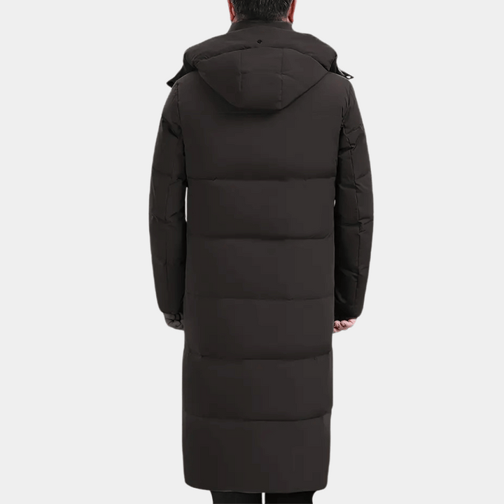 Zwarte lange winterjas met capuchon, gewatteerd ontwerp, rugaanzicht. Ideaal voor koude weersomstandigheden. Stijlvolle en warme herenjas.