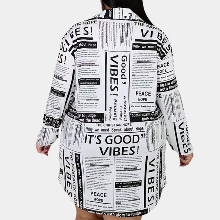 Achteraanzicht van een oversized wit shirt met zwarte tekstprints zoals "Good Vibes" en "Peace". Trendy mode, casual stijl, comfortabele pasvorm.