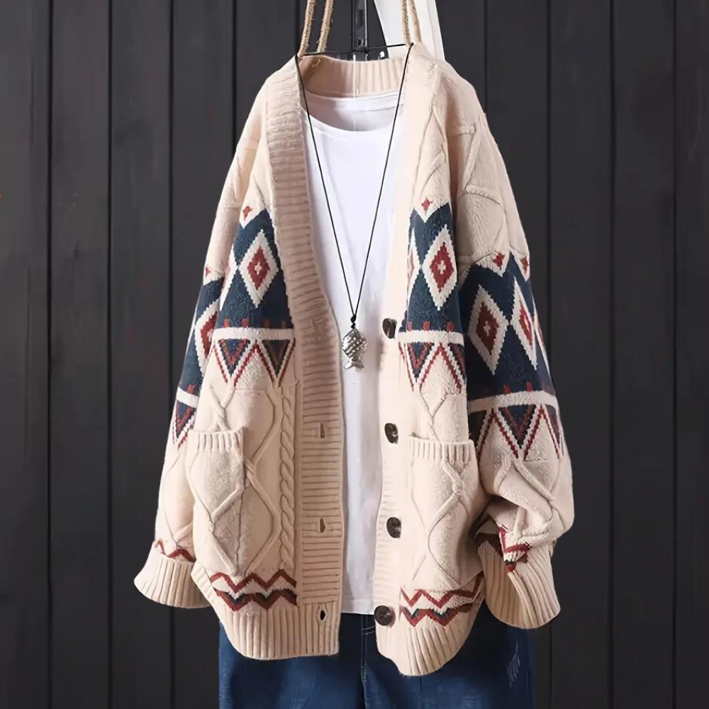 Beige gebreid vest met geometrisch patroon, houten knopen en zakken, gedragen over een witte T-shirt. Trendy herenkleding, casual stijl.