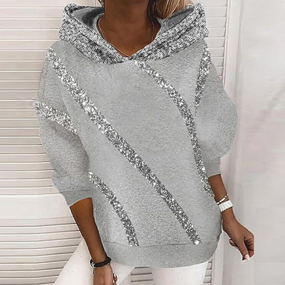 Grijze dameshoodie met glinsterende zilveren pailletten, lange mouwen en capuchon. Modieuze casual kleding voor dames, perfect voor herfst en winter.