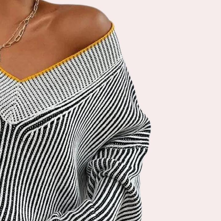 Vrouw draagt een gestreepte off-shoulder trui met gele rand, modieuze dameskleding, herfstmode, comfortabele en stijlvolle outfit.