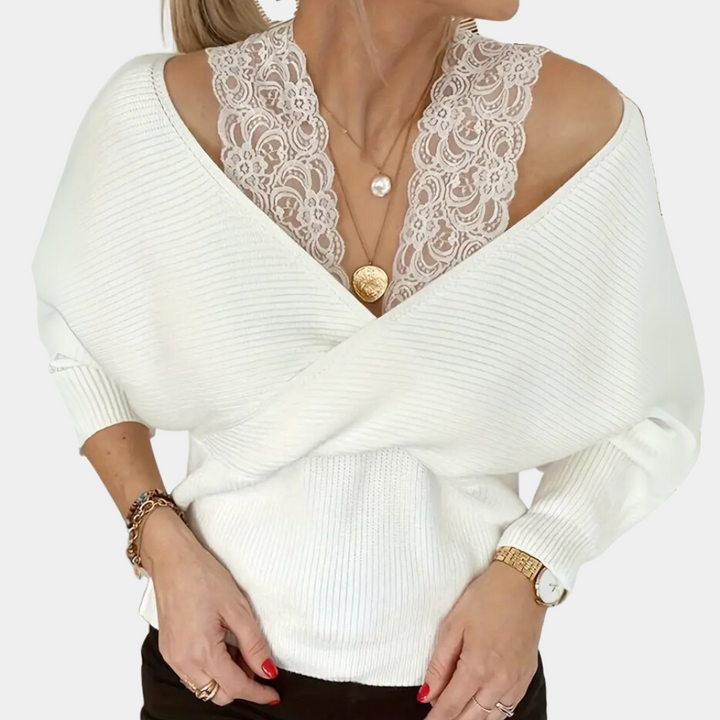 Vrouw draagt witte trui met V-hals en kanten top, gouden sieraden en horloge. Modieuze dameskleding, herfststijl, elegante casual outfit.