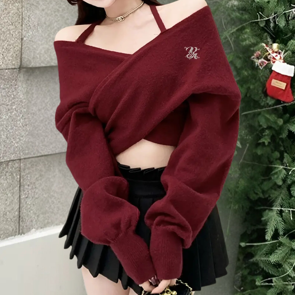 Vrouw in bordeauxrode off-shoulder trui en zwarte plooirok, kerstdecoratie op achtergrond. Modieuze winteroutfit, trendy dameskleding.