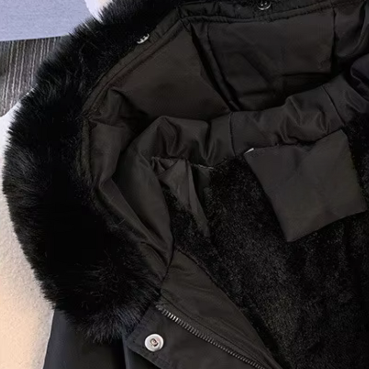Zwarte winterjas met bontkraag, gevoerde binnenkant en knoopsluiting, ideaal voor koude weersomstandigheden. Perfecte keuze voor wintermode.