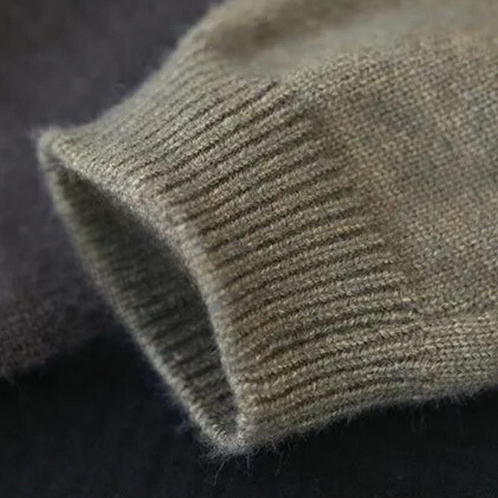Grijze wollen trui mouw detail, gebreid patroon, zachte textuur, hoogwaardige winterkleding, comfortabele en warme stof, close-up.
