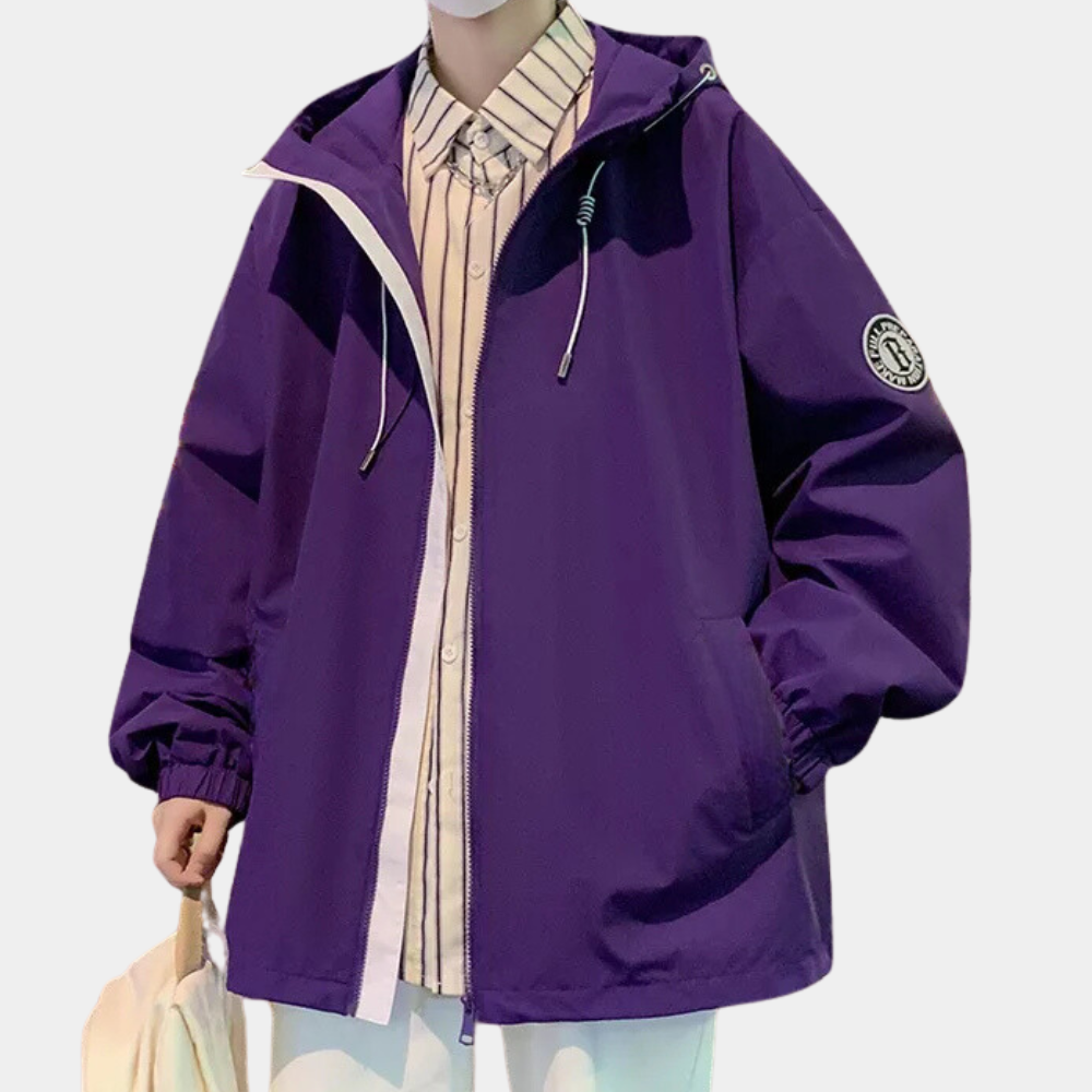 Paarse oversized jas met capuchon, ritssluiting en embleem op mouw, gedragen over gestreept overhemd. Modieuze unisex streetwear.