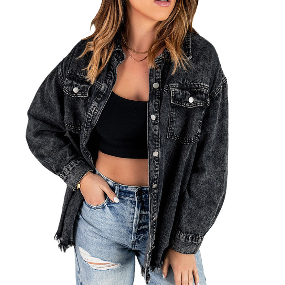Vrouw in zwarte denim oversized jas, zwarte crop top en gescheurde jeans. Modieuze casual outfit, trendy dameskleding, streetwear stijl.
