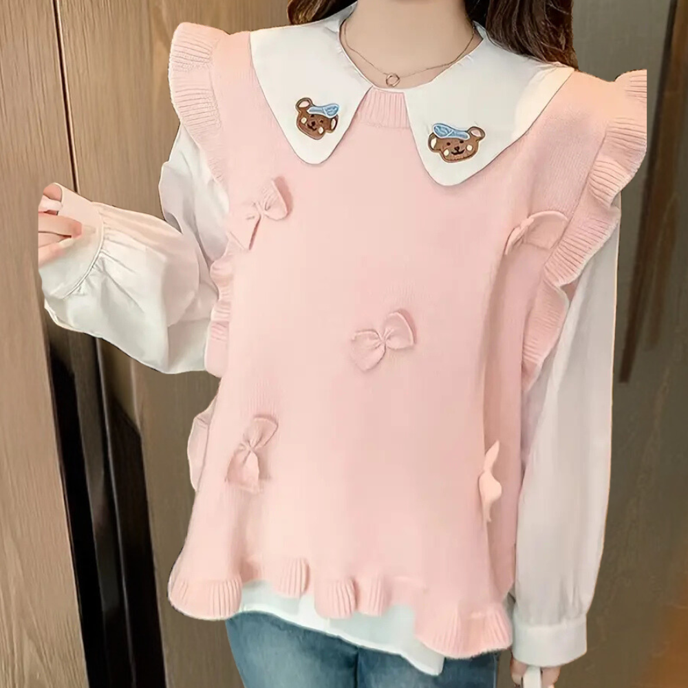 Roze gebreide trui met ruches en strikjes, witte kraag met berenmotief, gedragen door vrouw. Modieuze dameskleding, schattig en stijlvol ontwerp.