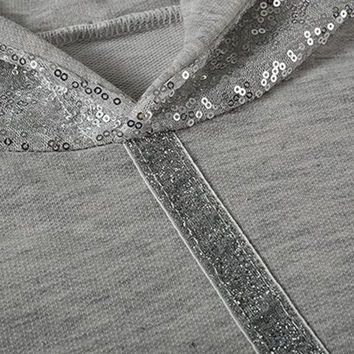 Grijze hoodie met pailletten, detail van capuchon en ritssluiting. Modieuze dameskleding, casual stijl, comfortabele stof.