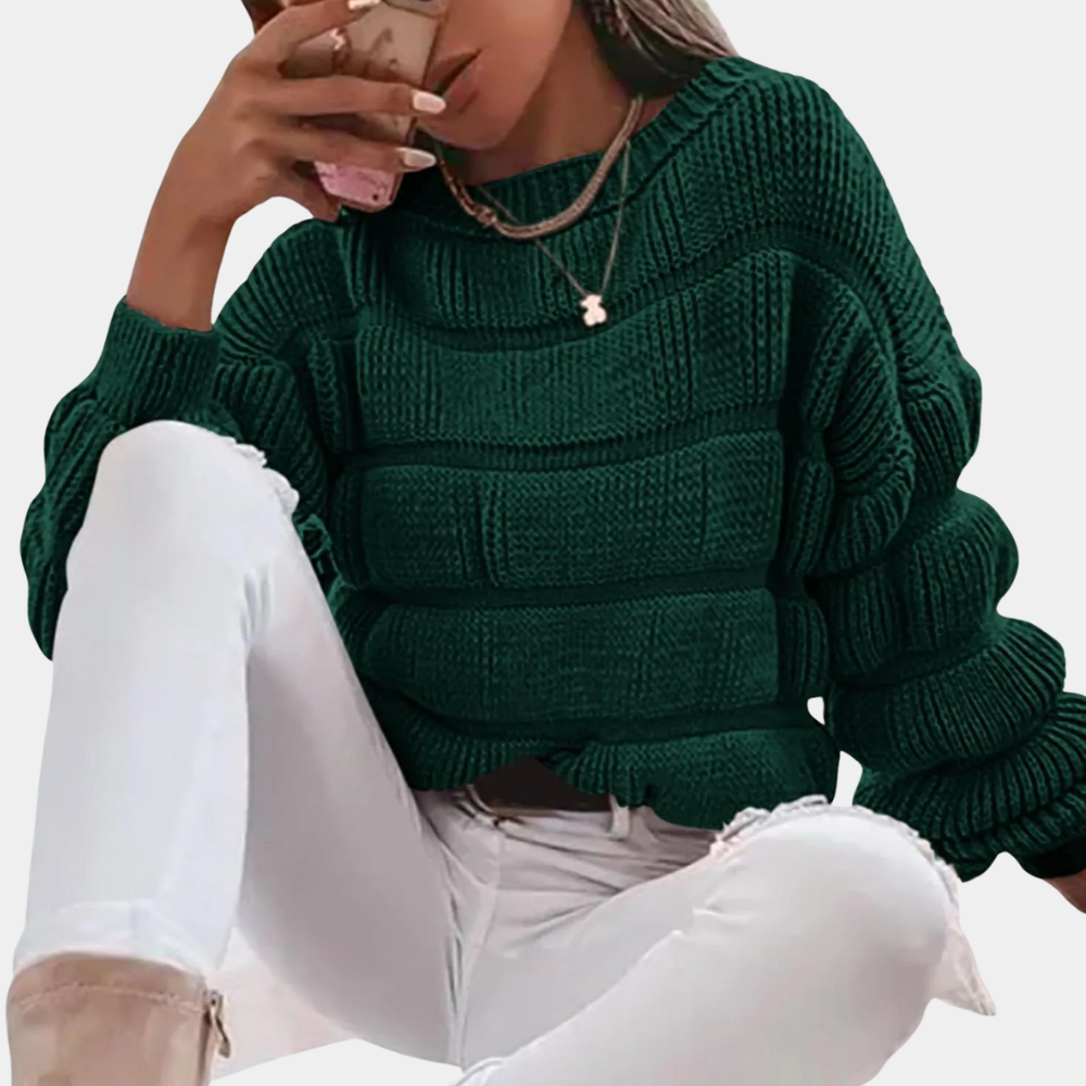 Vrouw in donkergroene gebreide trui met witte gescheurde jeans, drinkt koffie. Modieuze herfstkleding, casual stijl, comfortabele outfit.