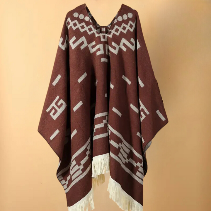 Bruine poncho met geometrisch patroon en witte franjes, bohemian stijl. Perfect voor herfstmode, warme en stijlvolle dameskleding.