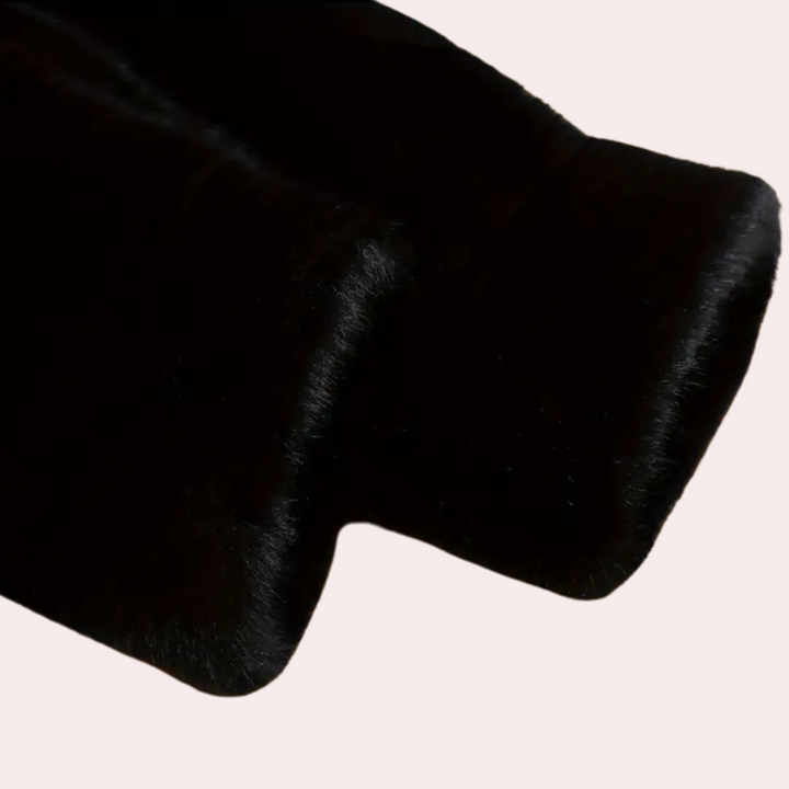 Zwarte bontstof close-up, glanzend en zacht, geschikt voor luxe kleding en accessoires. Hoogwaardige textielmaterialen voor modeontwerp.