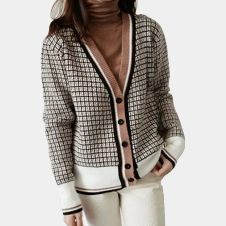 Vrouw draagt stijlvolle geruite cardigan met knopen, bruine coltrui en witte broek. Modieuze dameskleding, herfst-winter outfit.